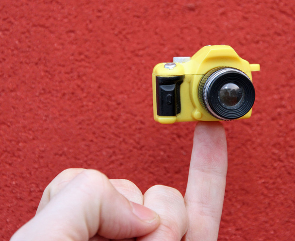 Little finger with a small toy camera - Valokuva, kuva