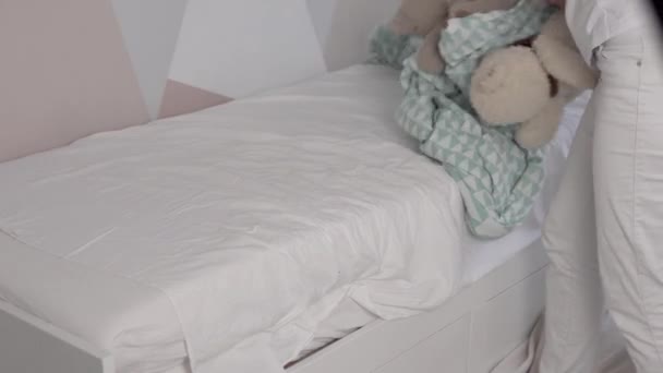 Η νοικοκυρά μητέρα καθαρίζει το παιδικό κρεβάτι αφού κοιμηθεί. - Πλάνα, βίντεο