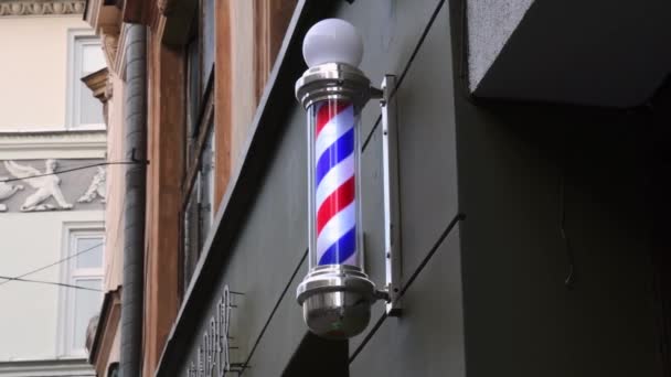 Raidallinen parturi napa pyörii seinään kampaaja myymälä vanhassa rakennuksessa - Materiaali, video