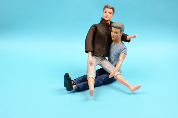 The toy man sits in the man's arms. Same sex love concept - Photo, Image