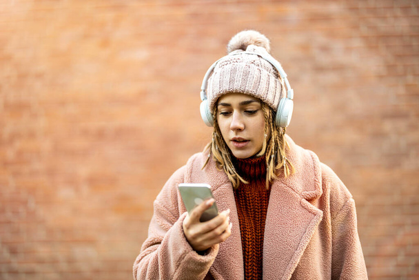 Happy young woman with headphones and cell phone - Φωτογραφία, εικόνα