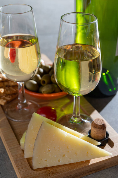 Glasses of dry cold fino sherry wine served with spanish tapas, manchego cheese, green olives, cheese crackers - Photo, Image