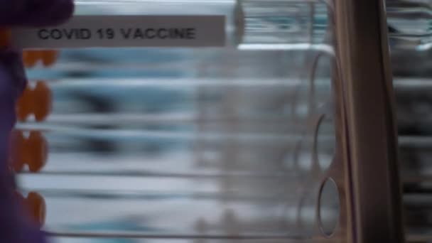Coronavirus covid 19 Impfstoff Reagenzgläser Ampullen in Rack gelegt. vertikales Video, Nahaufnahme, abgeschottet - Filmmaterial, Video