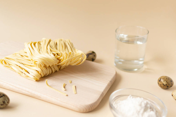 Natural homemade noodles with ingredients on a brown background. Horizontal orientation. Copy space. - Φωτογραφία, εικόνα