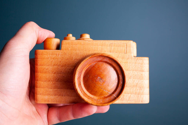 handmade wooden camera in hand on a dark green background, similar - Photo, Image