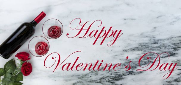 Red wine for a Happy Valentines Day on marble stone background setting with holiday text message - Photo, Image