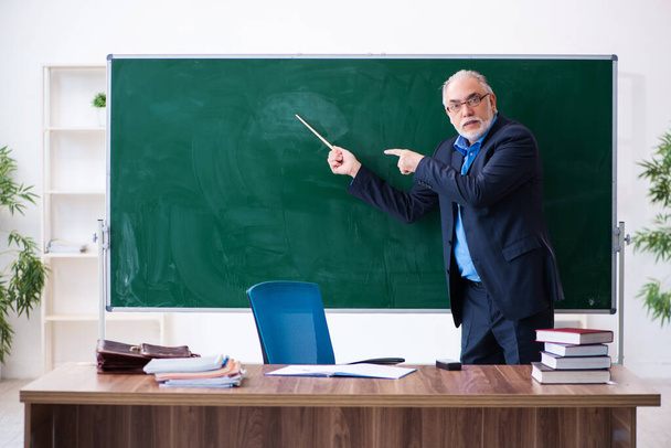 Old male math teacher in the classroom - Foto, Imagen