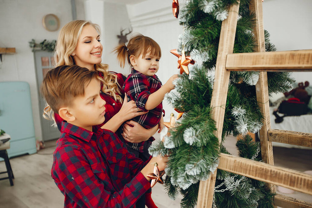 Family standing at home near christmas tree - Foto, Imagen
