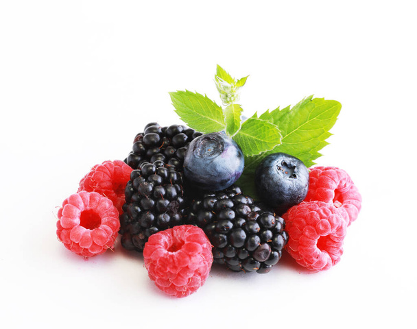 Mix berries with leaf. Various fresh berries isolated on white background. Raspberry, Blueberry, Cranberry, Blackberry and Mint leaves - Photo, image