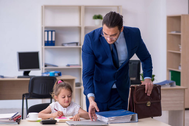 Jonge mannelijke werknemer en zijn kleine meisje in het kantoor - Foto, afbeelding