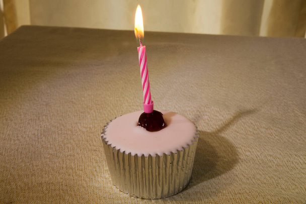 Birthday cakes with small lit candles on top representing the celebrant's age. Variations include cupcakes, cake pops, pastries, and tarts. The cake is often decorated with birthday wishes ("Happy birthday") and the celebrant's name - Photo, Image