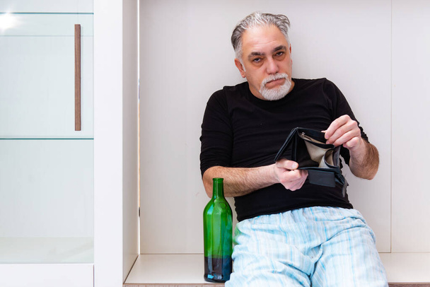 Old man drinking wine in the bedroom - Foto, afbeelding