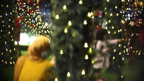 Flou focus de maman musulmane prendre la photo de fille jouer autour de l'arbre de Noël - Séquence, vidéo