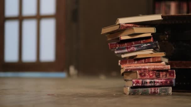 Kirjastonpino putoaa lattialle kirjastossa. Koulutus oppimisen käsite vanhassa kirjastossa, pino kasoittain kirjallisuutta teksti akateeminen arkisto - Materiaali, video