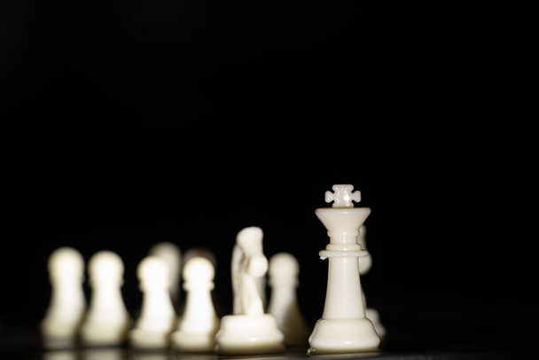 white chess pieces on a board on a black background, playing chess - Foto, Imagem