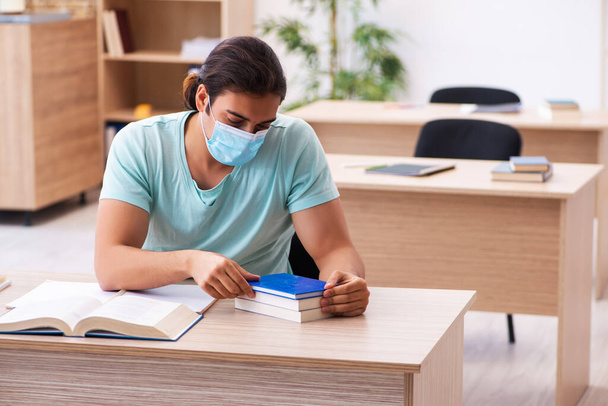 Young male student sitting in the classroom wearing mask - Photo, Image