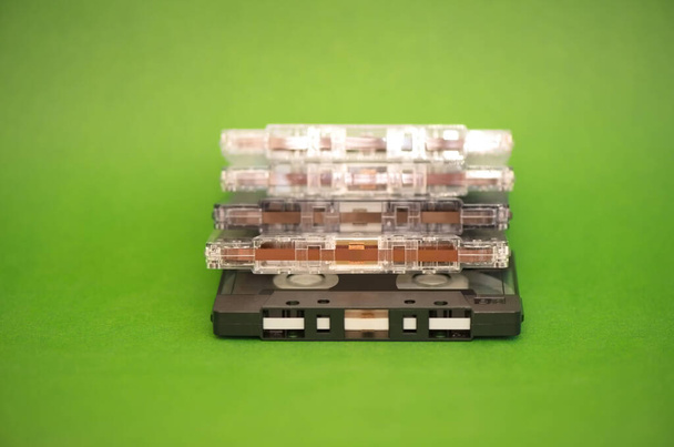 Una pila de casetes de cinta de audio de plástico sobre fondo verde - Foto, imagen
