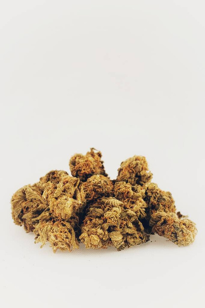 Primo piano delle cime di cannabis a fiore secco della Strada Sativa davanti a uno sfondo bianco - Foto, immagini