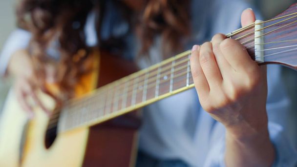 Manos de mujer tocando guitarra acústica. Adolescente chica creando canción con guitarra - Foto, Imagen