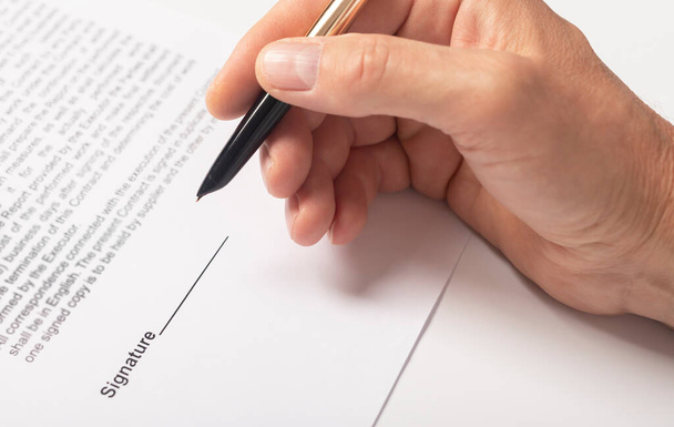 Contract signing concept. Businessman hand with pen over document closeup. - Foto, afbeelding