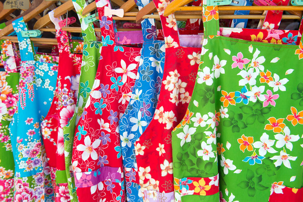 Барвисті жіночі сукні з квітковим візерунком на вішалках
 - Фото, зображення