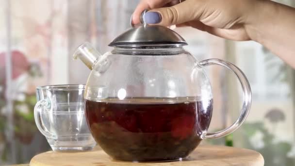 Une théière pour le thé est recouverte sur le dessus d'un couvercle - Séquence, vidéo