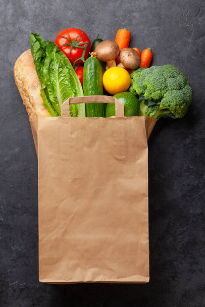 Verschiedene gesunde Lebensmittel in Recycling-Papiertüten auf einem Steintisch. Draufsicht flach lag mit Kopierraum - Foto, Bild