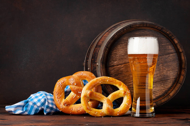 Lager beer with homemade pretzels and old wooden beer barrel. With copy space - 写真・画像