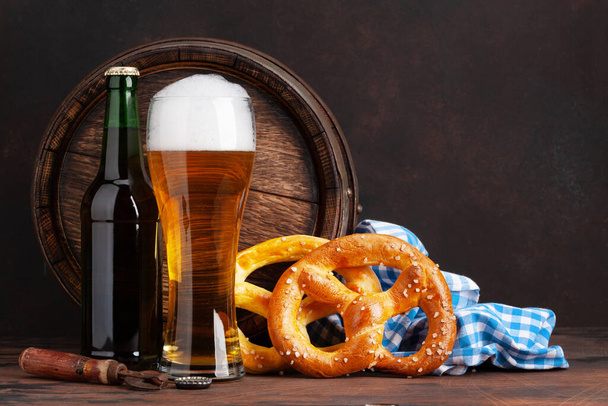Cerveza de cerveza con pretzels caseros y barril de cerveza de madera vieja. Con espacio de copia - Foto, Imagen