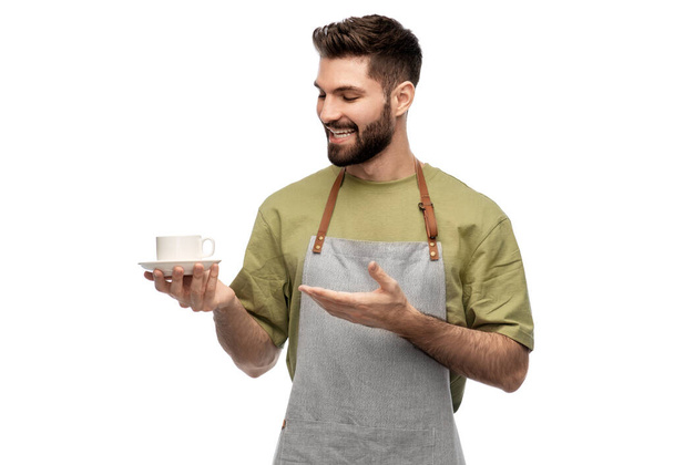 happy smiling waiter in apron with cup of coffee - Zdjęcie, obraz