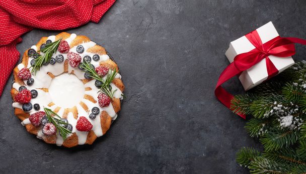 Χριστουγεννιάτικο κέικ με μούρα και δενδρολίβανο. Top view επίπεδη θέσει με αντίγραφο χώρο για τους χαιρετισμούς σας - Φωτογραφία, εικόνα