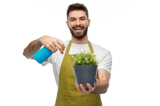 happy smiling male gardener moisturizing flower - 写真・画像