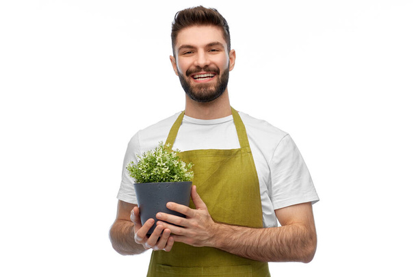 happy smiling male gardener with flower in pot - Foto, imagen