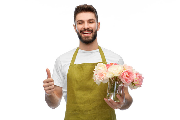 happy male gardener with flowers showing thumbs up - Φωτογραφία, εικόνα