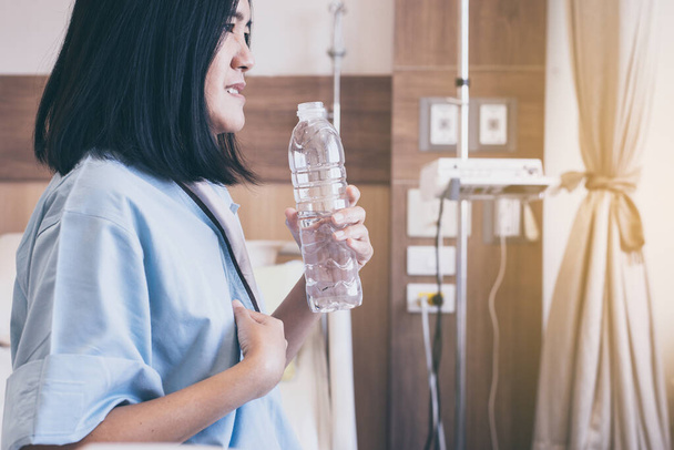 Asian women patient having or symptomatic reflux acids at hospital,Gastroesophageal reflux disease,Drinking water - Foto, imagen