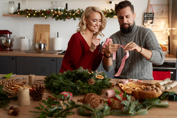 Woman teaching a man to make ribbons for a wreath                                - 写真・画像