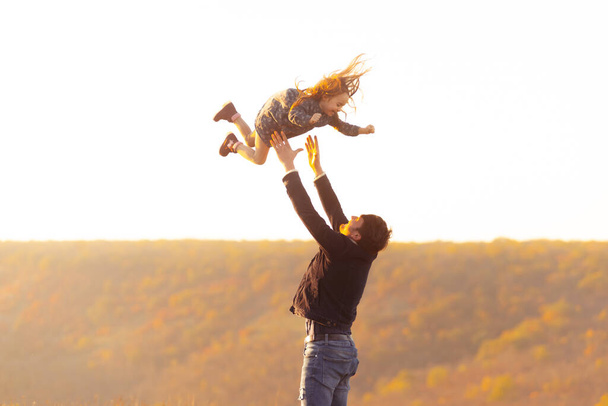 家族の時間だ。娘と遊んでいる父親の写真を投げ上げてキャッチ - 写真・画像