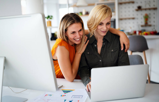 Happy designers lesbian couple planning, brainstorming at startup in office - Fotó, kép
