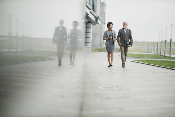 Fotografía de dos exitosos empresarios multiétnicos caminando frente al edificio de oficinas. - Foto, Imagen