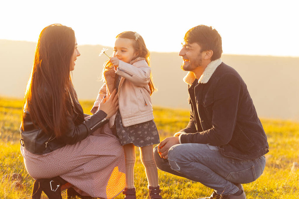 Счастливая семья. Фотография семьи, проводящей время вместе в парке или поле - Фото, изображение