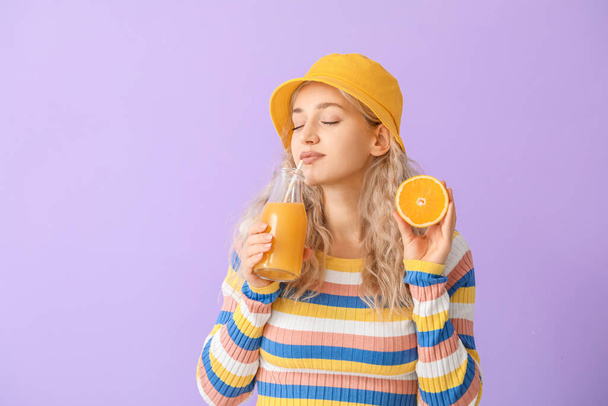 Красивая молодая женщина с апельсиновым соком на фоне - Фото, изображение