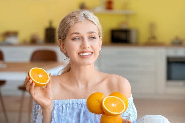 Beautiful young woman with oranges at home - Foto, Imagen