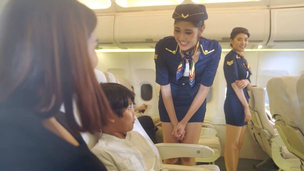 Cabin crew provide service to family in airplane - Photo, Image