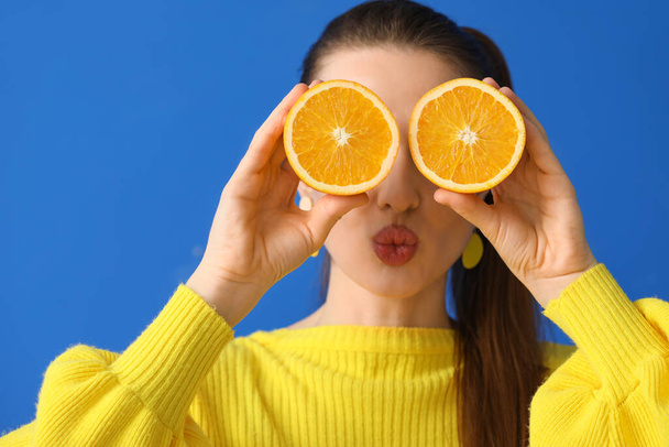 Funny young woman with orange slices on color background - Photo, Image