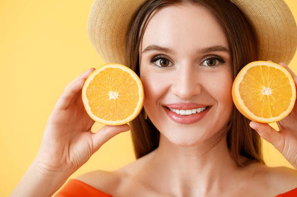 Mulher bonita com fatias de laranja no fundo de cor - Foto, Imagem