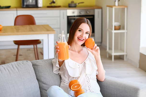 Güzel genç bayan evde portakal suyu içiyor. - Fotoğraf, Görsel
