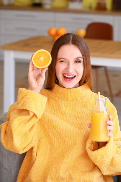 Beautiful young woman drinking orange juice at home - Foto, afbeelding