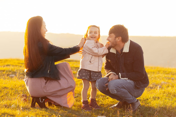 Семейное фото мамы-папы и милой маленькой девочки, проводящей время вместе - Фото, изображение