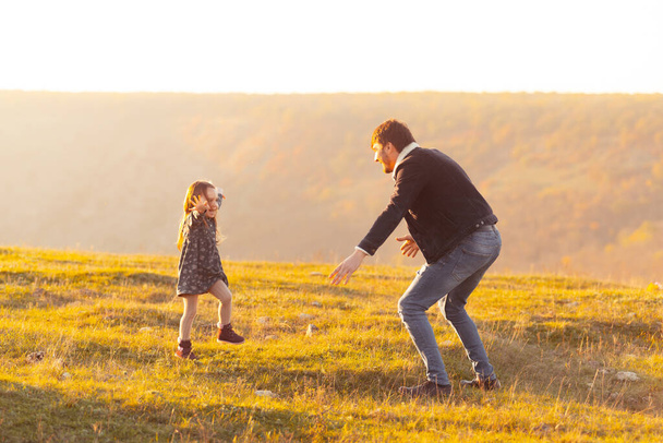 Family time. Photo of cute little girl running in dad direction to catch her - Foto, Imagen