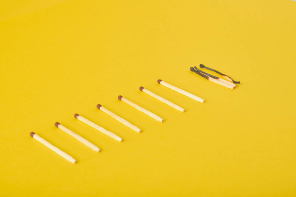 burnt and new matches on a yellow background - Φωτογραφία, εικόνα